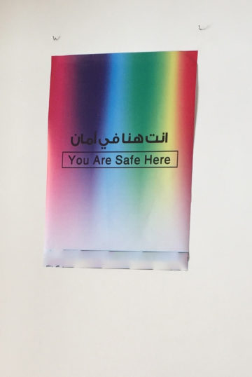 Bilingual "You Are Safe Here" poster (Arabic and English)